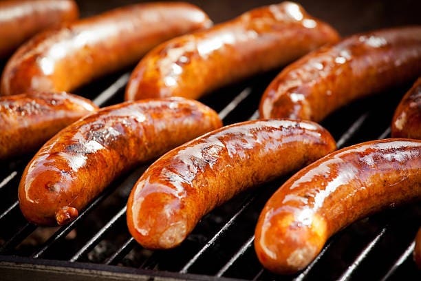 A grill with several hot dogs on it.