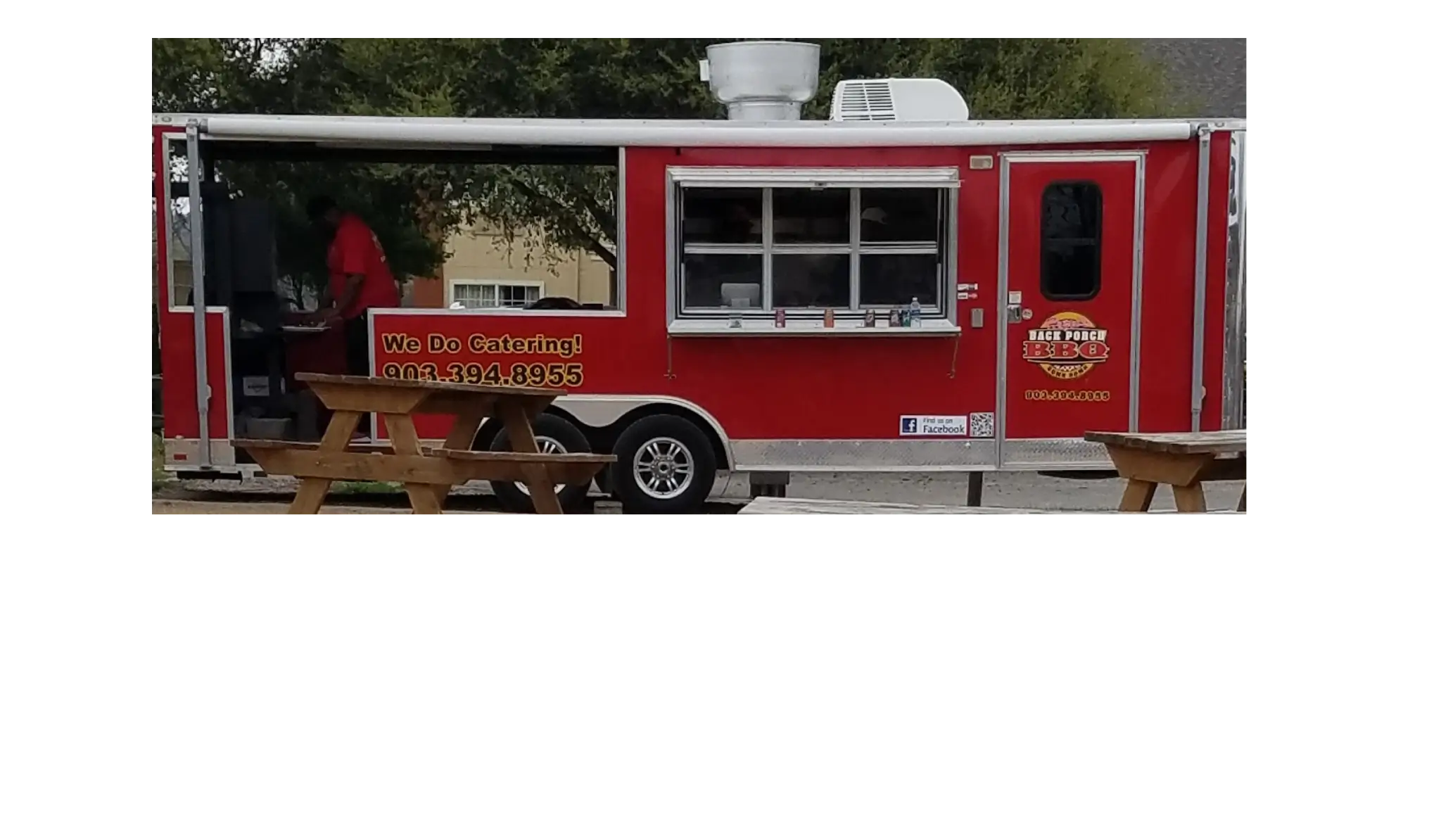 A red food truck parked in the parking lot.